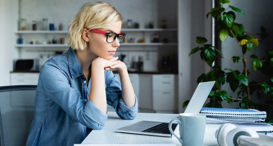 Individual using laptop in home workspace